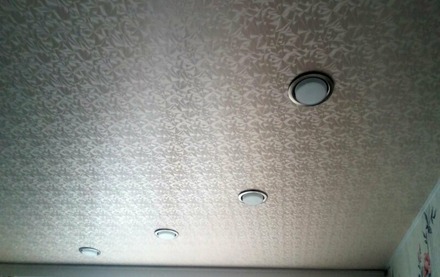 Фактурный натяжной потолок в спальне бежевый со светильниками